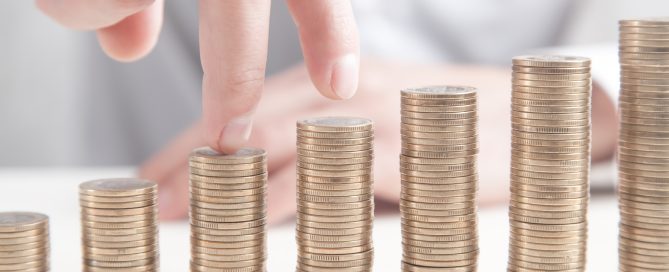 Fingers walking up on stacks of coins. Growth
